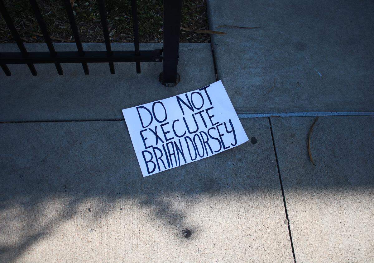 A sign reading “Do not execute Brian Dorsey,” lays on the ground among protesters on the corner of 39th Street and Troost Avenue in Kansas City Tuesday evening.