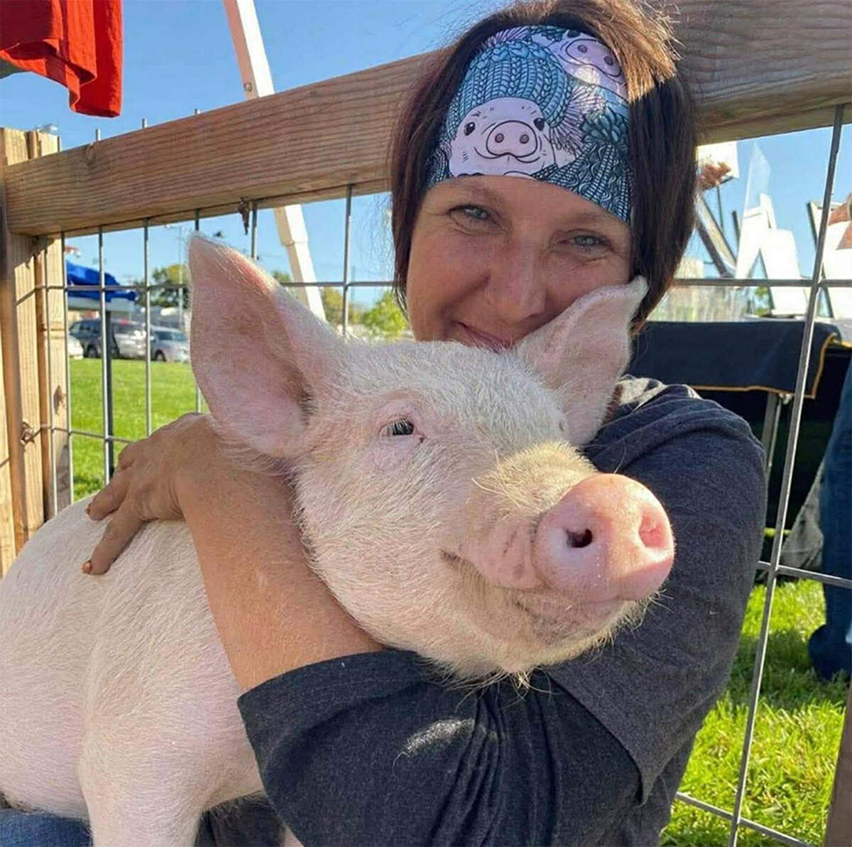 Angela Jones-Willey, Kansas City Pig Rescue Network’s secretary and treasurer, with her beloved pig, Thad, who she adopted after he was rescued after falling off of a truck at just a few weeks old.