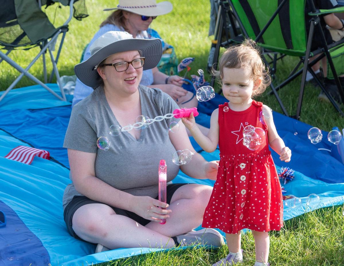 Emily Pitts watched as her daughter, Callie Pitts, 2, blew bubbles during the Celebration at the Station on Sunday.