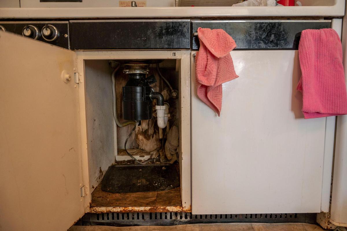 A resident at Cross-Lines Retirement Center shows the mold and rust under the sink of their apartment on Wednesday, March 2, 2022.