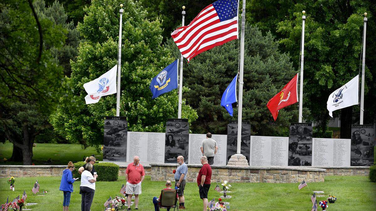 A scattering of carefully spaced family members and friends gathered at Resurrection Catholic Cemetery in Lenexa Monday to pay a Memorial Day tribute to those who have passed. By Rich Sugg