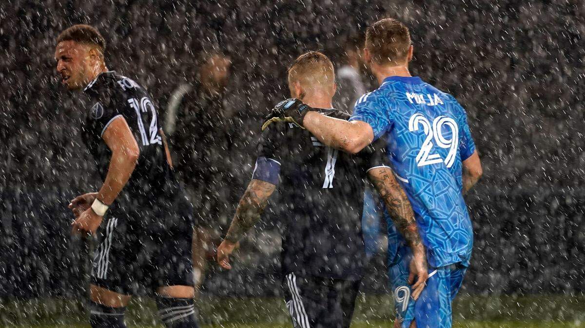 Sporting Kansas City players Kortne Ford (12), Johnny Russell (7) and Tim Melia (29) walk off the field in the rain after their MLS soccer match against the Columbus Crew on Saturday at Children’s Mercy Park.