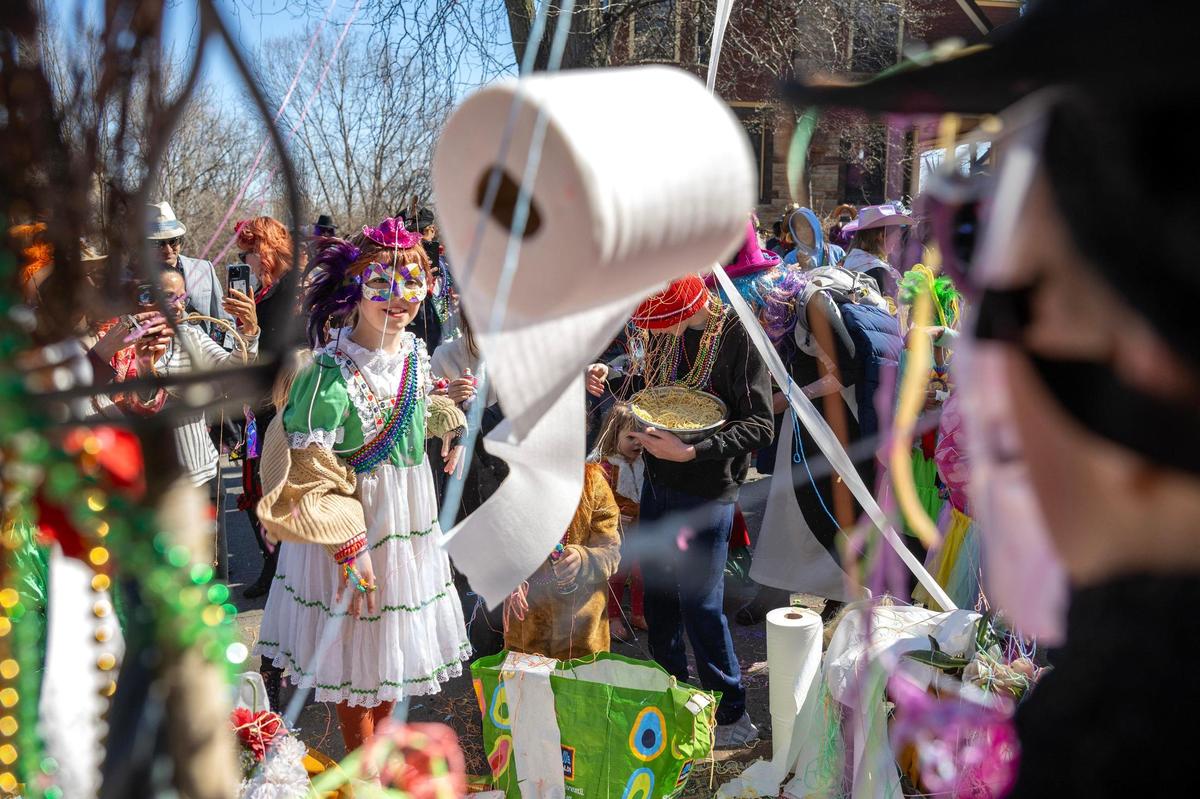 Children use silly string, toilet paper and confetti to cover Maximón, the patron saint of bad behavior, during the Krewe de Prank parade on Sunday, March 2, 2025, in Kansas City.