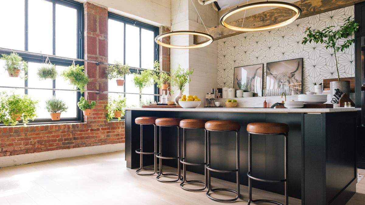 West Elm’s Cora leather counter stools ($249 each) provide stylish seating space in the black and white kitchen of the “Queer Eye” set in downtown Kansas City.
