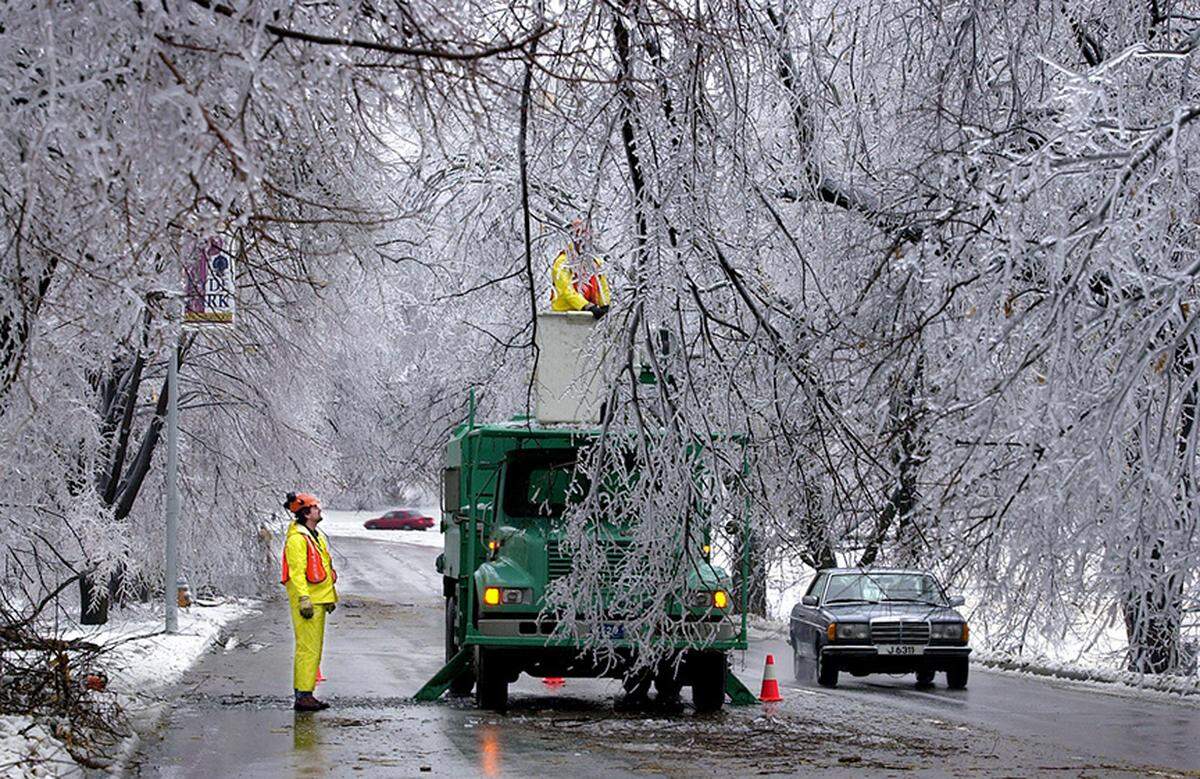 Mark Polston, left, and his co-worker, Matt Huling sawed down several hanging branches laced with ice on Gilliham Road near 37th Street in 2002.