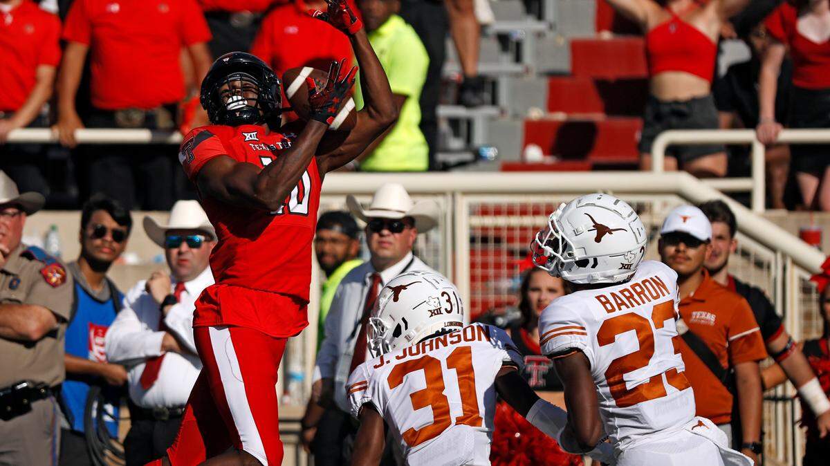 Texas Tech’s Trey Cleveland (10) catches the ball over Texas’ Jamier Johnson (31) and Jahdae Barron (23) during the second half of an NCAA college football game Saturday, Sept. 24, 2022, in Lubbock, Texas.