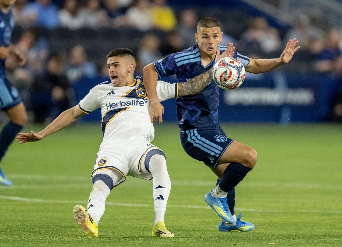 LA Galaxy midfielder Gabriel Pec (11) and Sporting Kansas City forward Dejan Joveljic (9) compete for the ball in the second half at Sporting Park on Wednesday, May 13, 2026, 2026, in Kansas City, Kansas. Sporting KC defeated the LA Galaxy, 3-1.