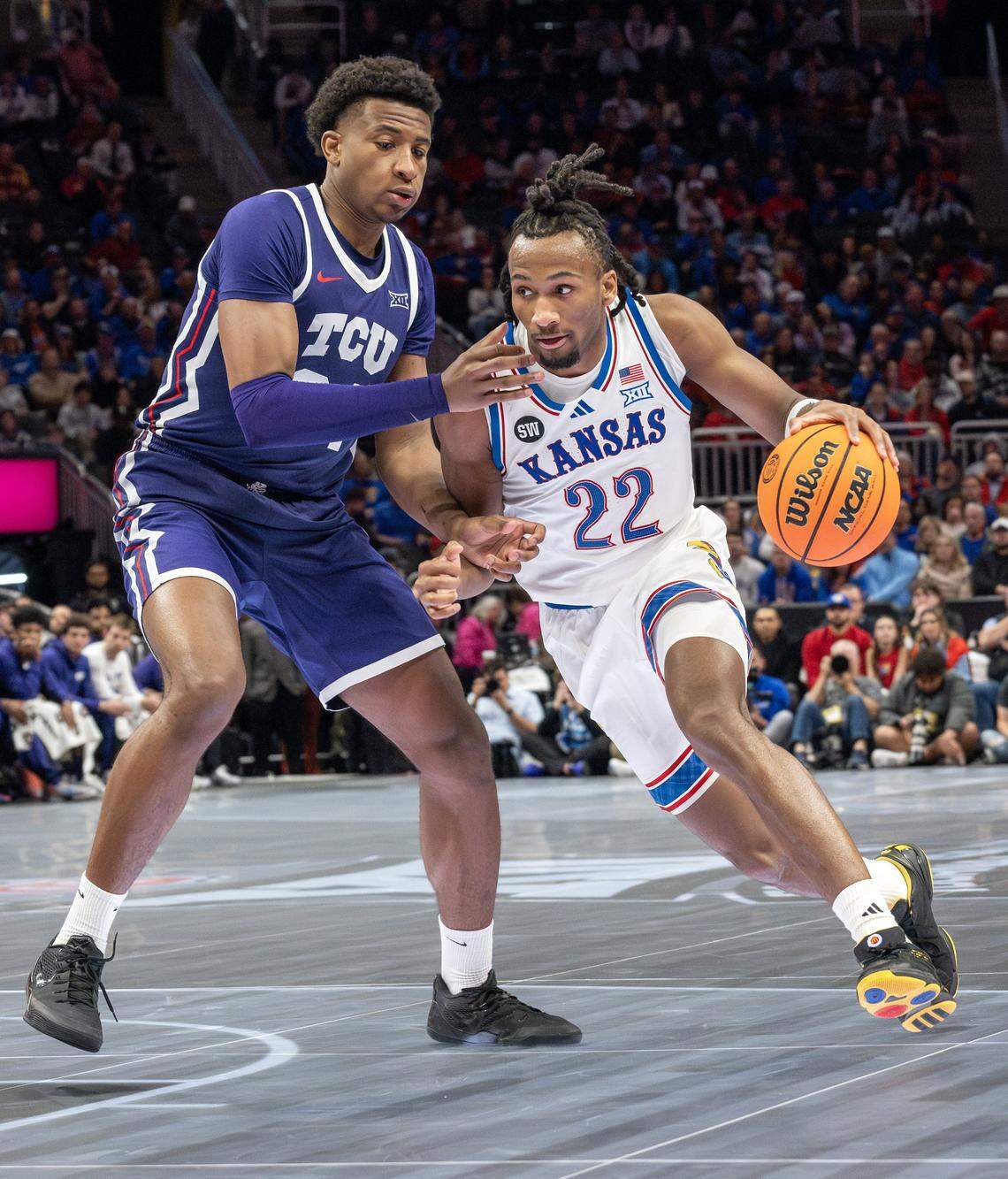 Kansas Jayhawks guard Darryn Peterson (22) shields the ball from Texas Christian University Horned Frogs forward Xavier Edmonds (24) during the second half of a Big 12 Men's Basketball Tournament game at T-Mobile Center on Thursday, March 12, 2026, in Kansas City.