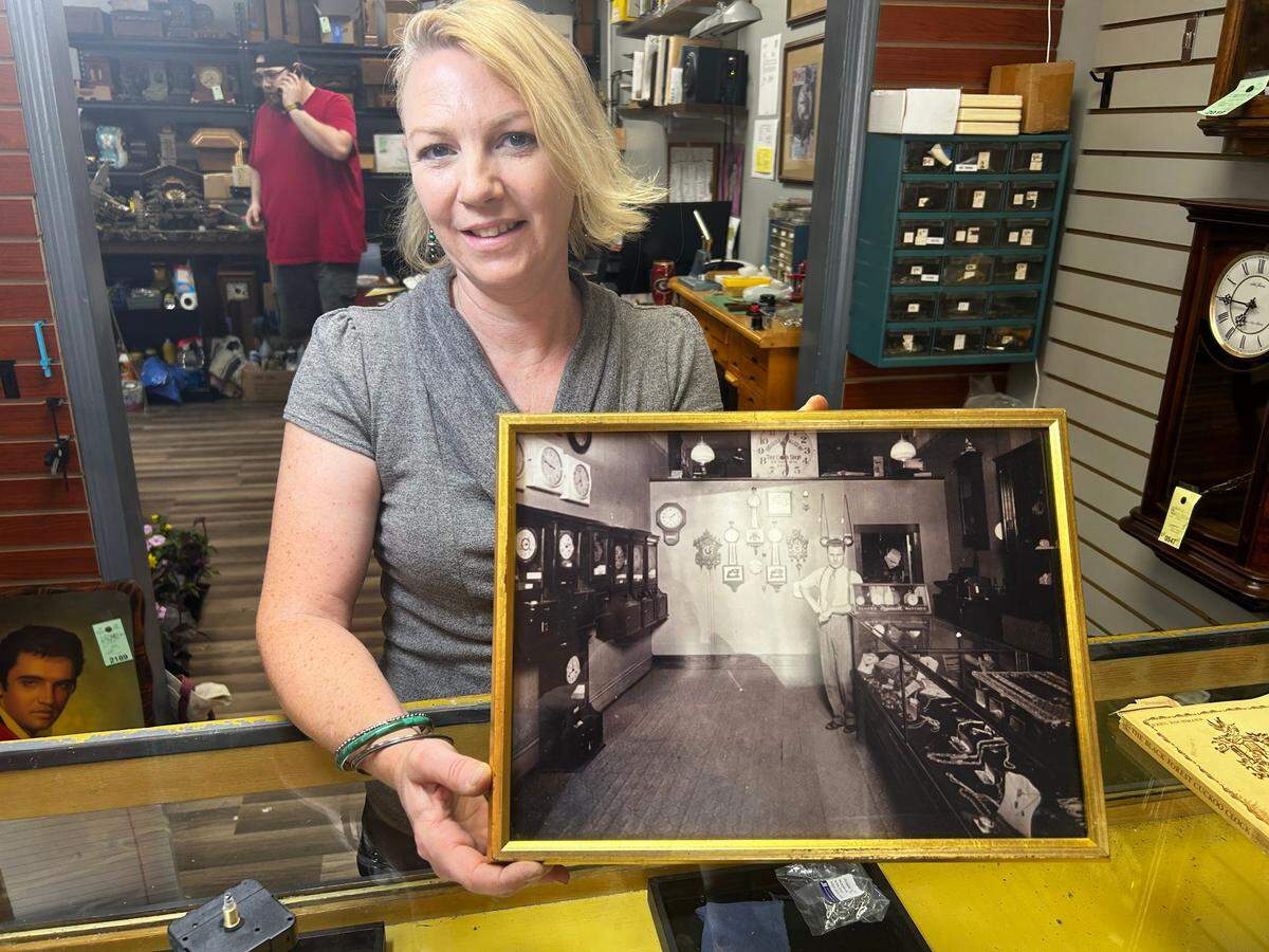 Beth Woolsey with a framed photo of Joe Beverley, who opened The Clock Shop in downtown Kansas City in 1905.