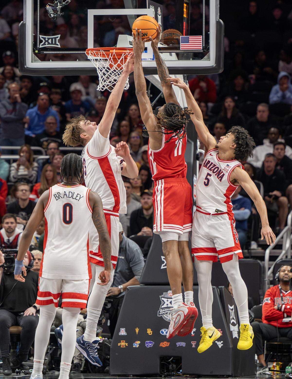 Houston Cougars forward Joseph Tugler (11) makes a layup over Houston Cougars center Jacob McFarland (13) during the second half of the Big 12 Men's Basketball Tournament Championship game at T-Mobile Center on Saturday, March 14, 2026, in Kansas City.