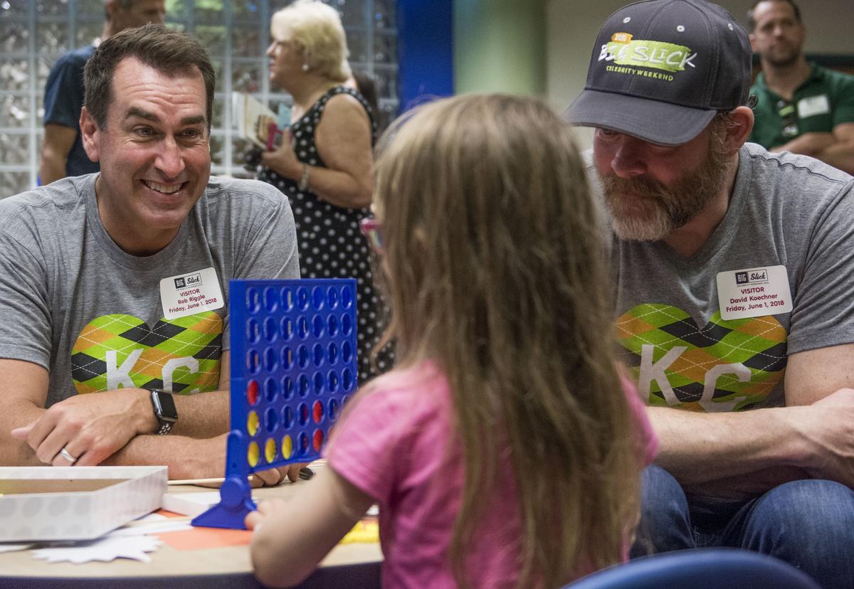 Rob Riggle (left) and David Koechner played Connect 4 with a Children's Mercy patient after their press conference Friday morning.