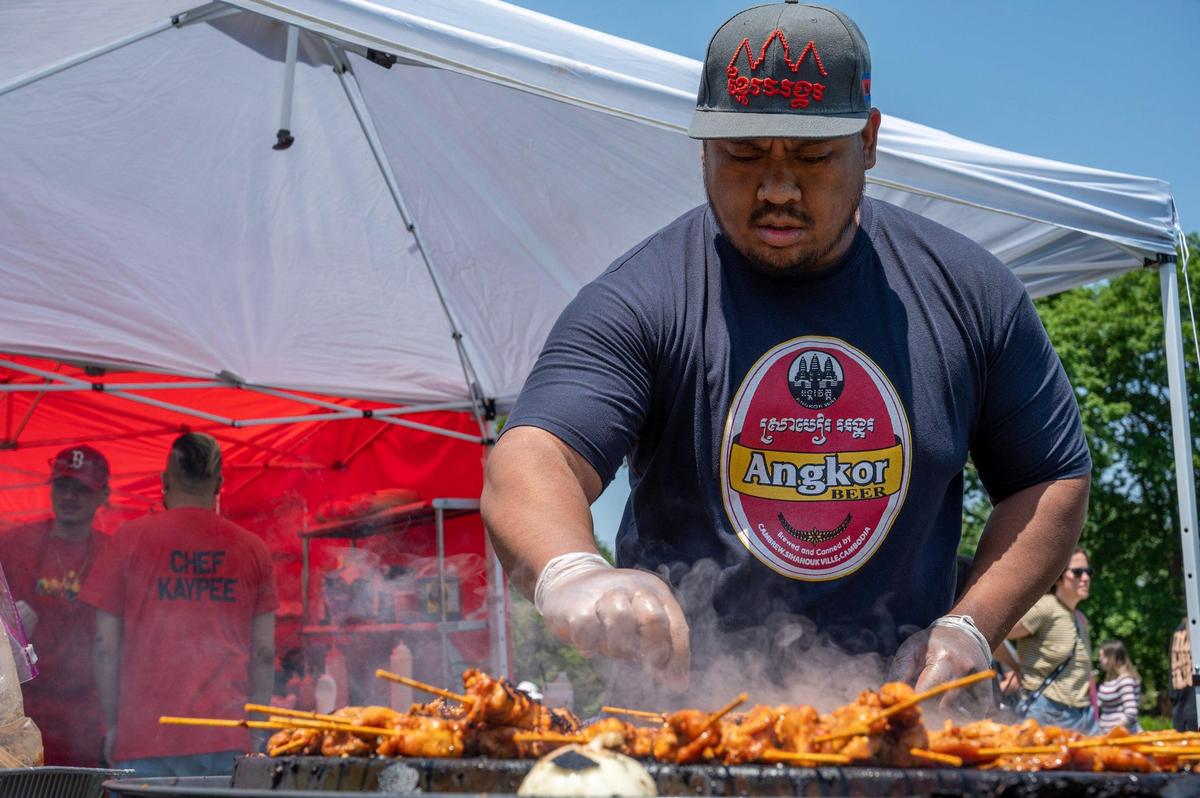 Jimmy Trou grills chicken kabobs at the Laos House booth during the AAPIconic Festival on Saturday, May 20, 2023, in Kansas City.