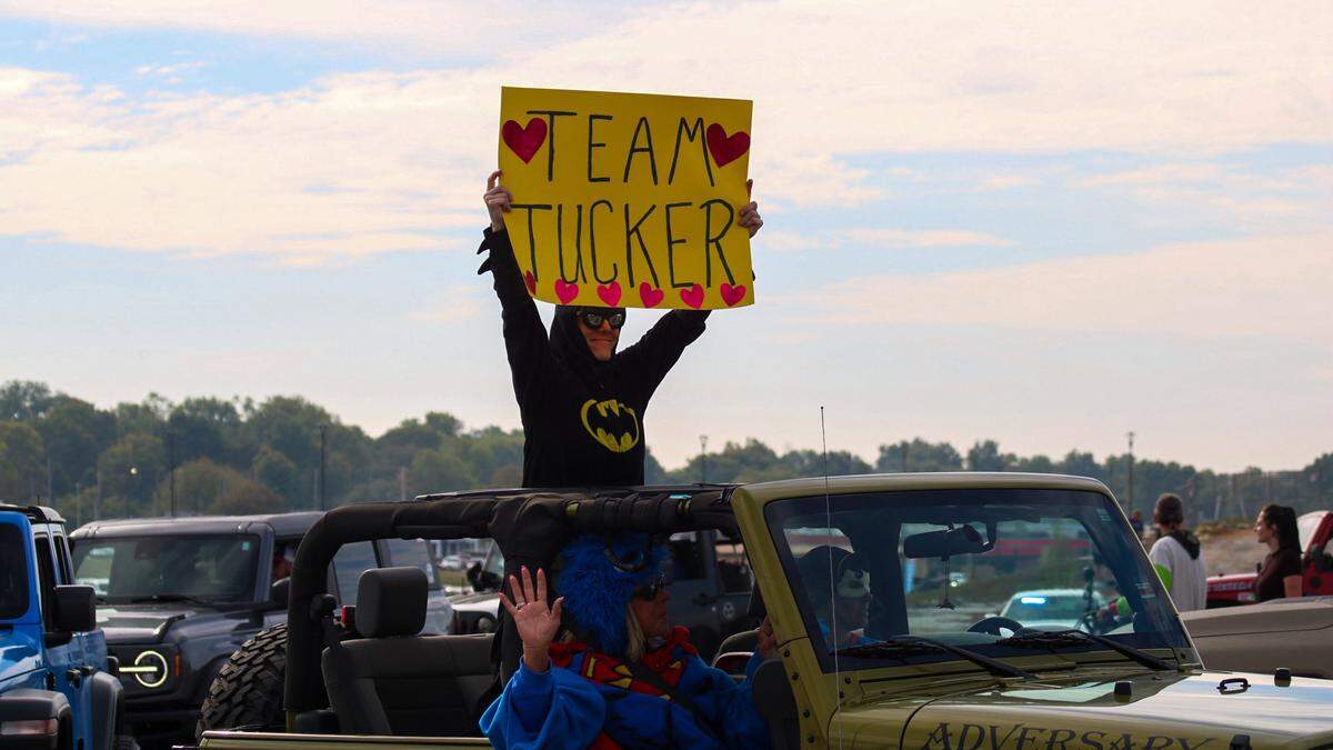 A person holds a sign that reads “Team Tucker” during a parade on Oct. 11, 2025, honoring 3-year-old Tucker Langford, who battles a terminal illness.