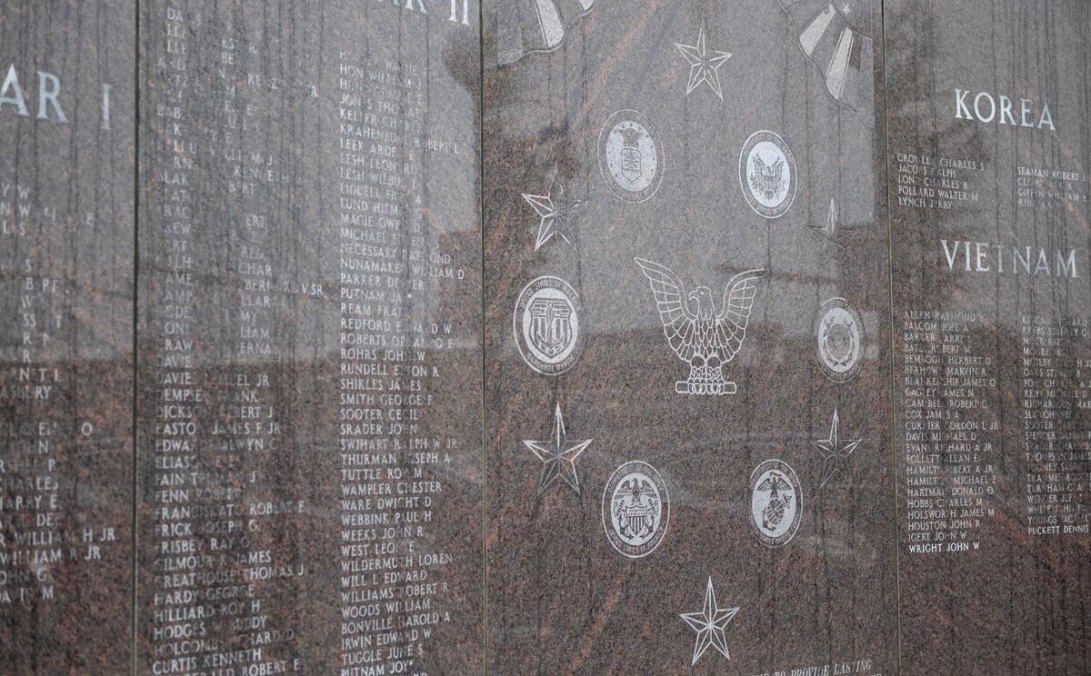 The names of fallen soldiers from several wars along with the emblems from the various armed services are featured on this memorial.
