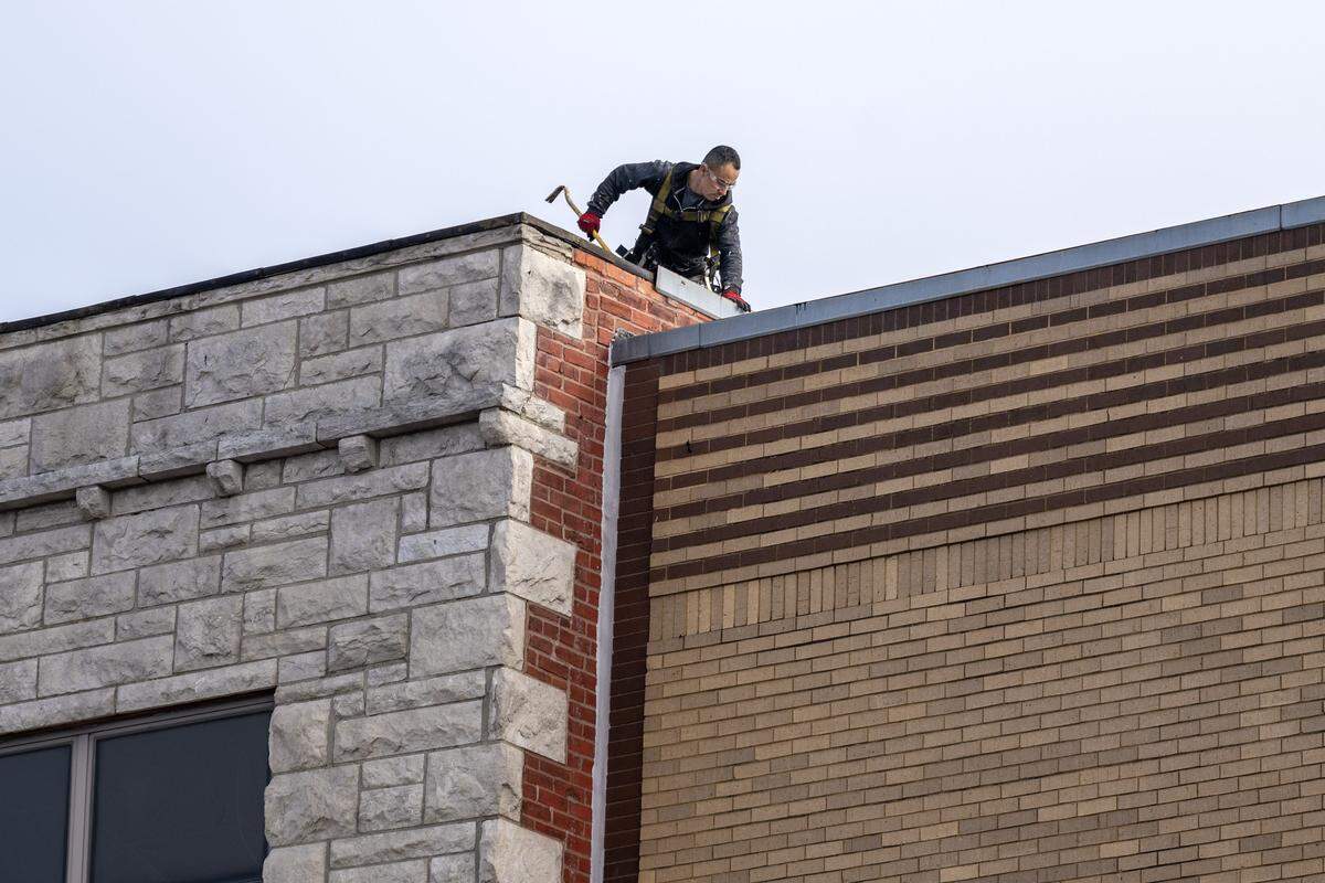 A construction worker is seen on the roof of the Jeserich Building at 31st and Main Street on Wednesday, Nov. 19, 2025, in Kansas City.