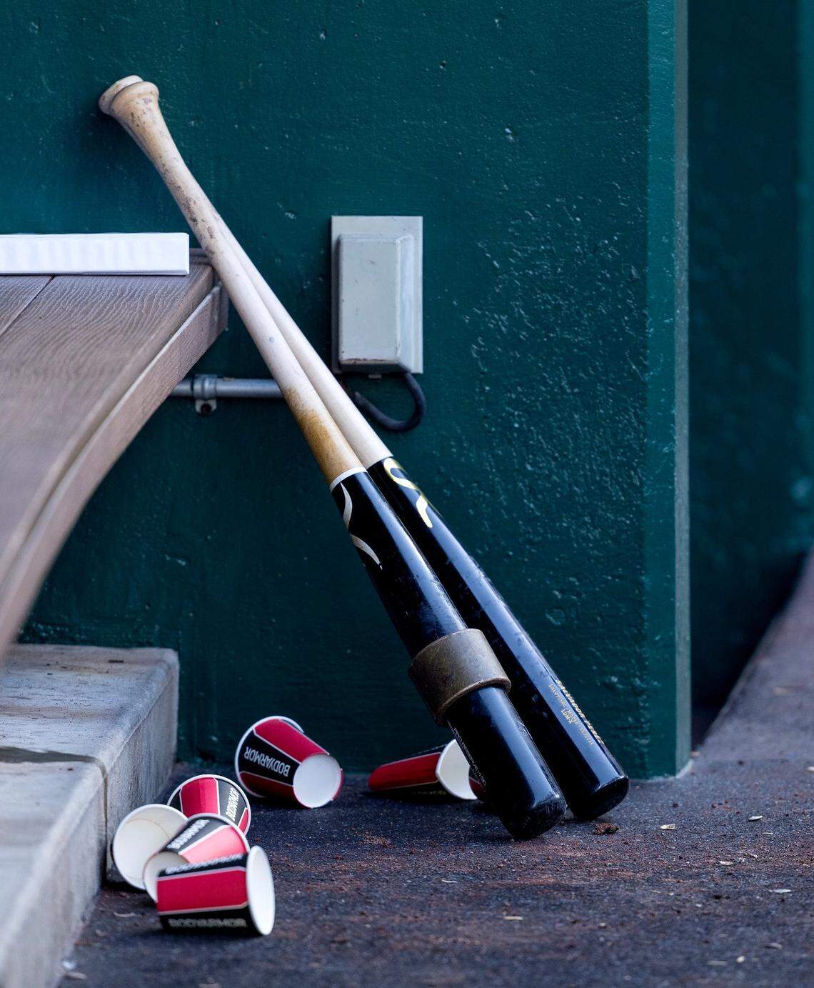 Empty water cups and a couple of bats clutter a corner of the Kansas City Royals dugout during the Royals’ home opener Thursday against the Minnesota Twins.