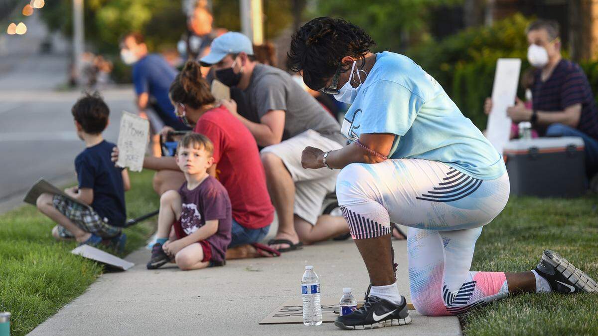 Kim Bruce, of Lenexa, kneeled for eight minutes of silence at a Black Lives Matter George Floyd rally Sunday near 95th Street and Antioch Road in Overland Park.