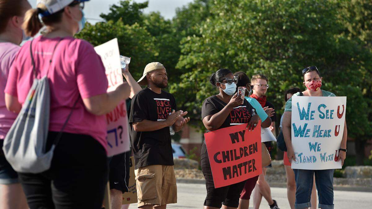 Lashiya and Ramon Ellis, second and third right, who have a child attending Lee’s Summit West and another attending Greenwood Elementary, protest with students, parents, teachers and alumni of the Lee’s Summit School District outside the district’s administration office Tuesday, June 9, 2020, to demand more accountability on race relations.