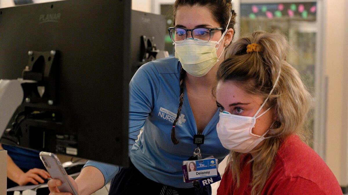 In the COVID intensive care unit at University Health, Delaney Swanson, left, a registered nurse, shows Andi Piper, a nurse resident, the charting process.