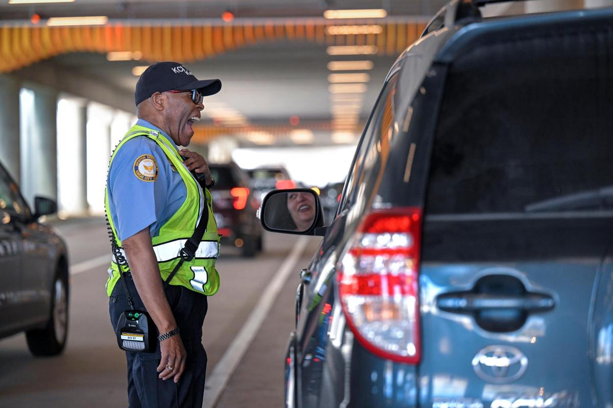 With a smile, Clyde Kemp Jr., a traffic control officer, encourages a driver to keep it moving as they arrive Friday to pick up passengers at Kansas City International Airport
