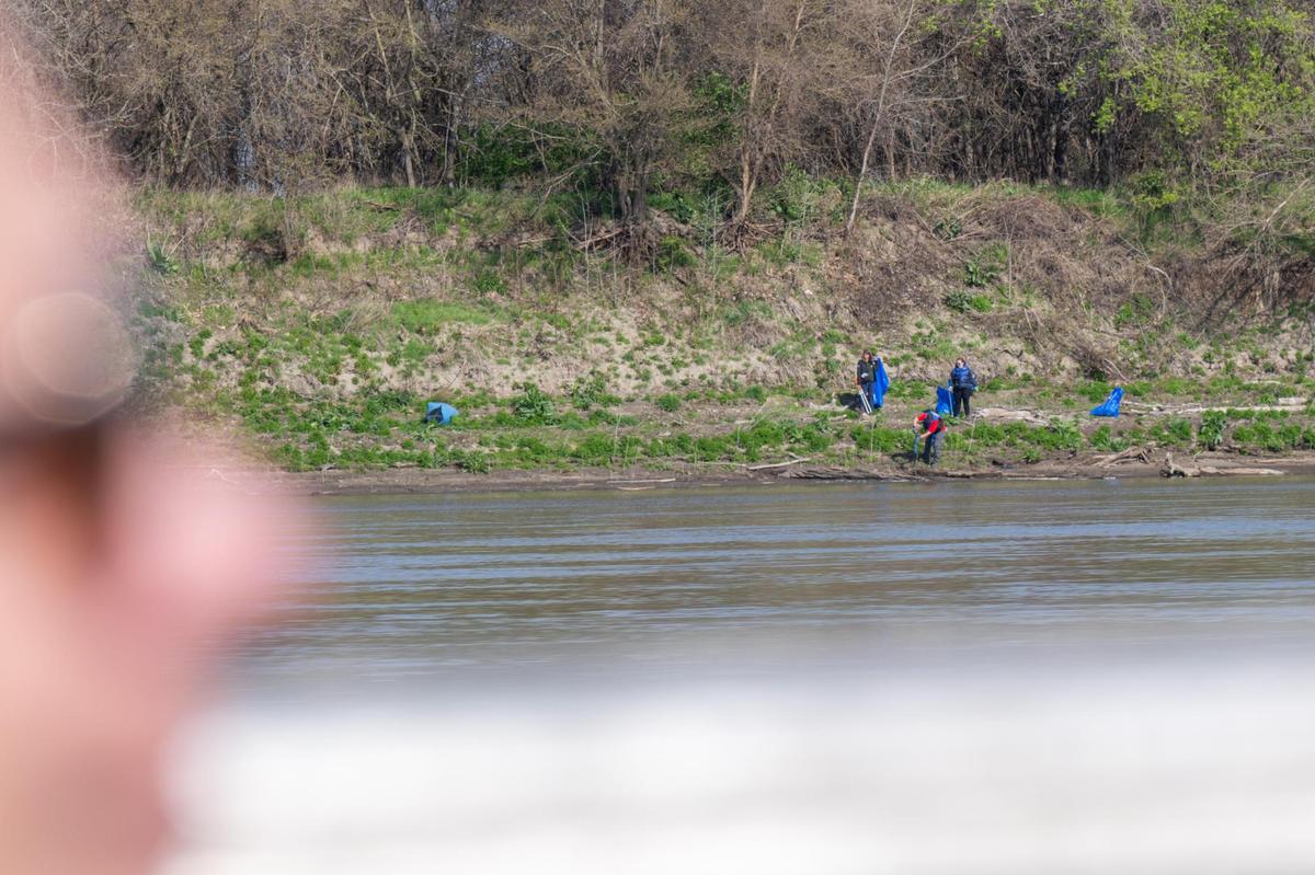 Volunteers clean up trash at the bank of the Missouri River Saturday during an event held by Missouri River Relief.