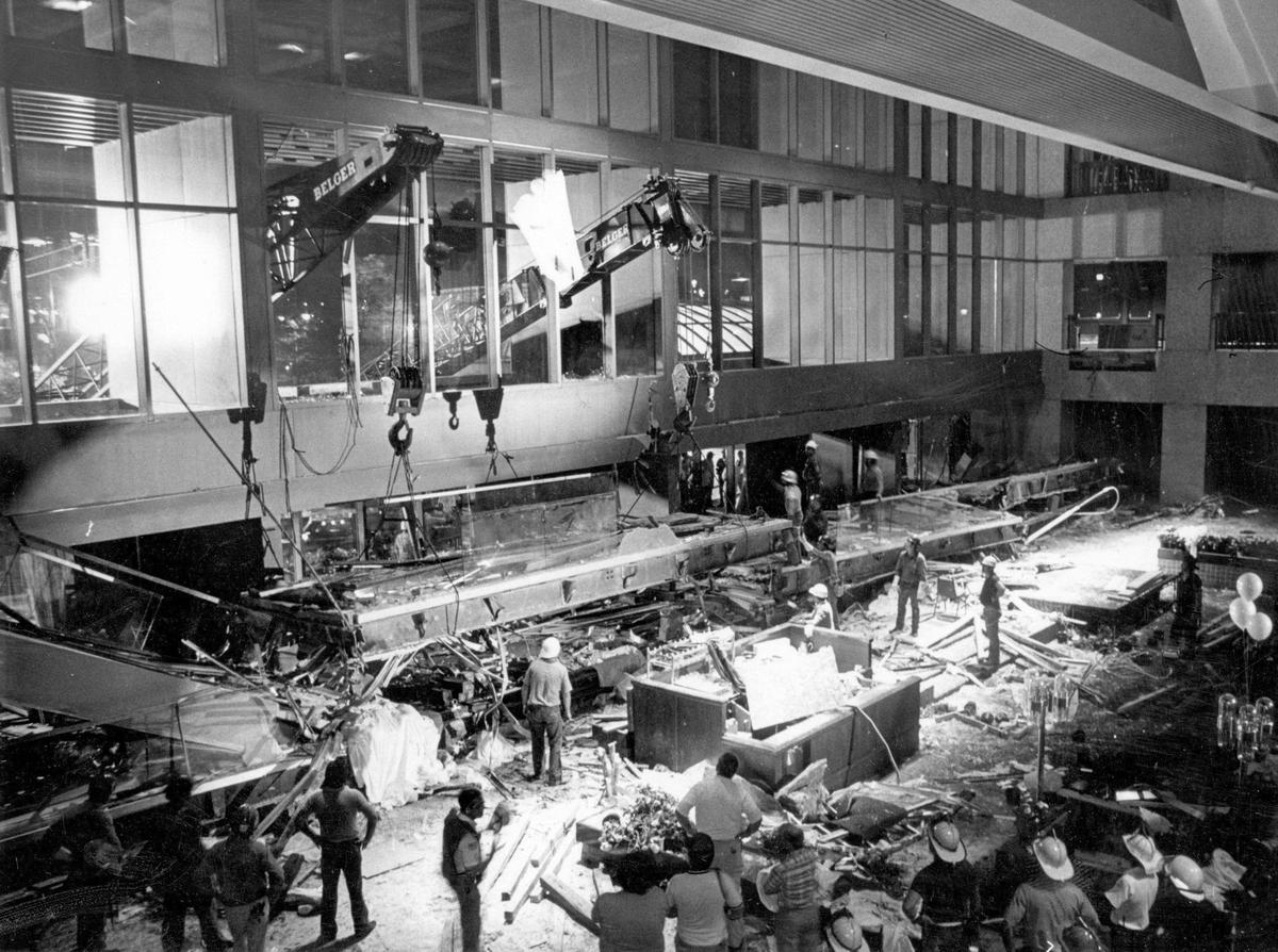 The booms of large cranes were positioned through windows on the front of the lobby at the Hyatt Regency Hotel to lift the collapsed skywalks so emergency crews could reach victims trapped beneath the wreckage.