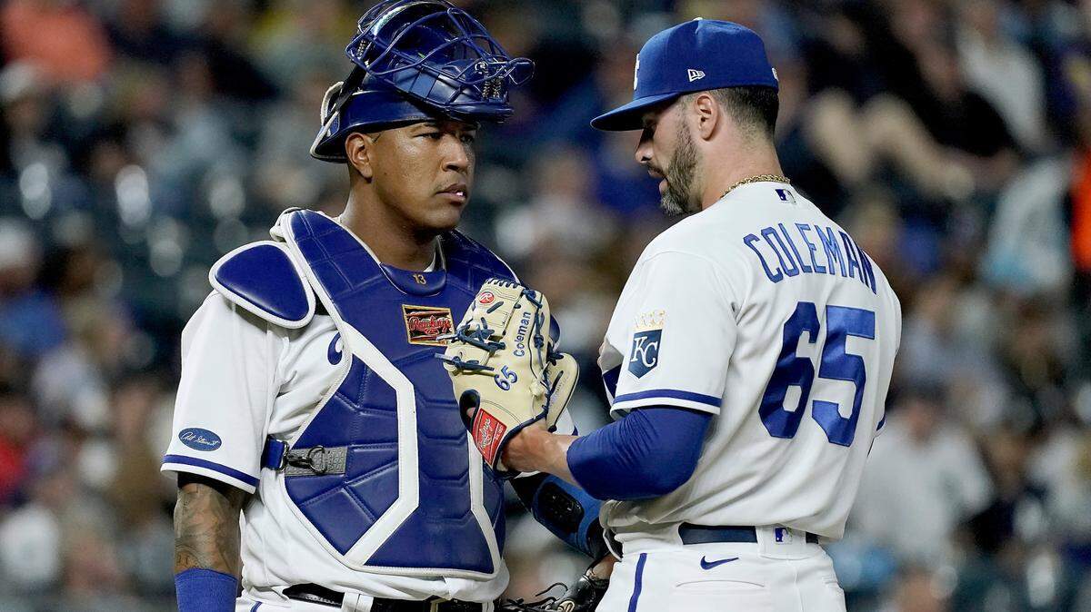 Kansas City Royals relief pitcher Dylan Coleman (65) and catcher Salvador Perez meet on the mound during the seventh inning of a baseball game against the New York Yankees Friday, April 29, 2022, in Kansas City, Mo. (AP Photo/Charlie Riedel)