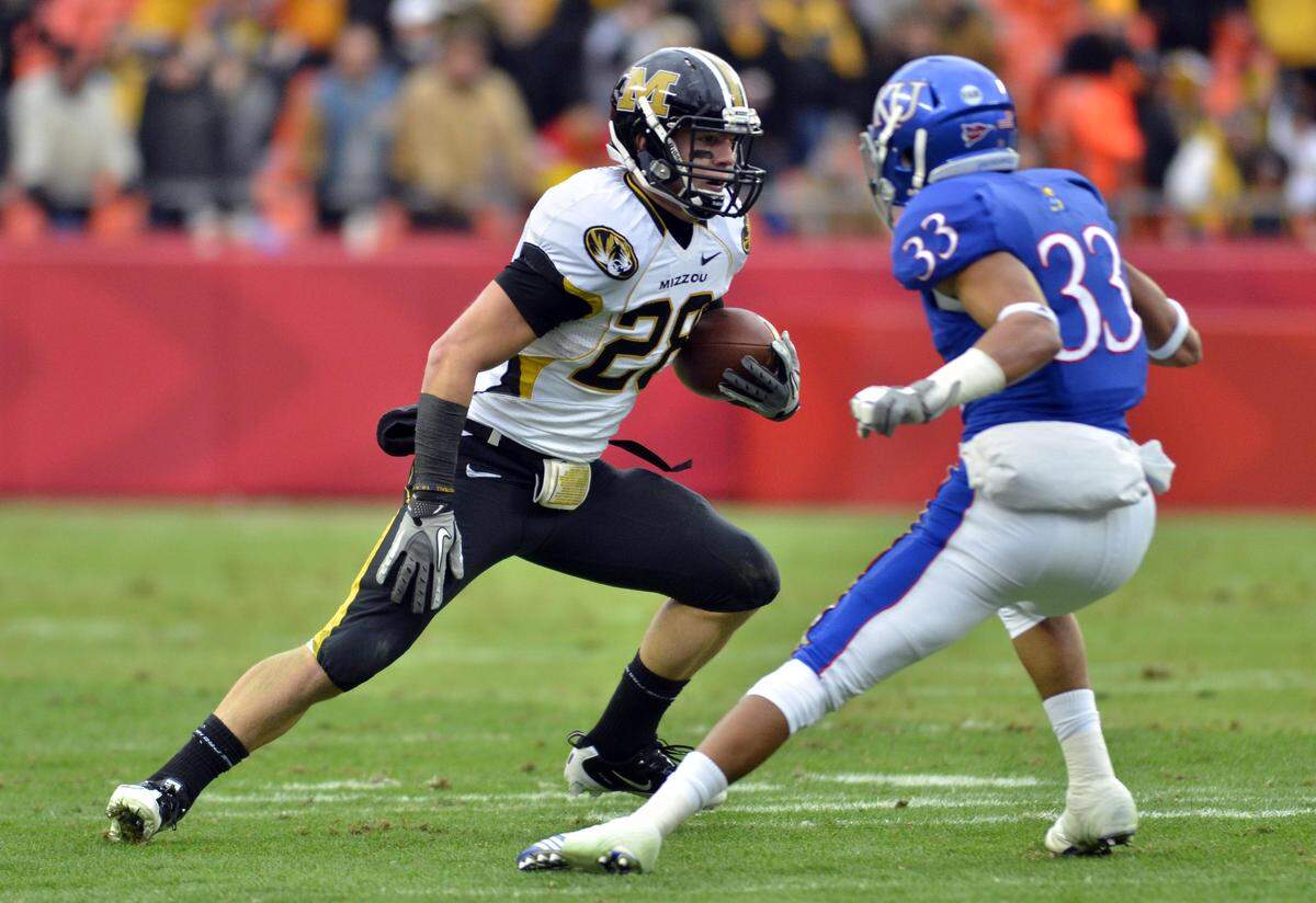Missouri Tigers wide receiver T.J. Moe (28) runs as Kansas Jayhawks cornerback Tyler Patmon (33) attempts to make a tackle in the first quarter at Arrowhead Stadium on November 26, 2011.
