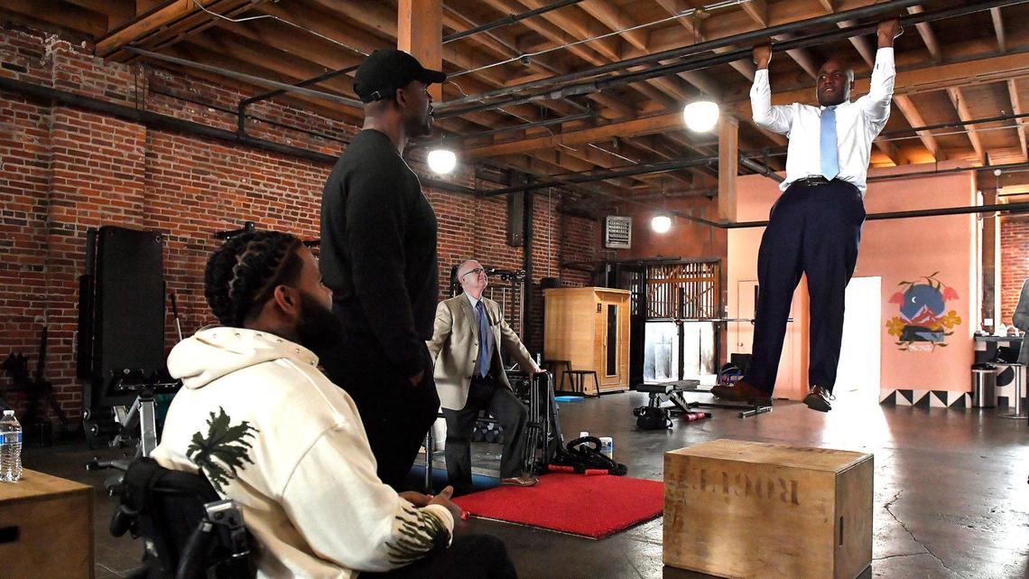 To honor Black History Month, Kansas City Mayor Quinton Lucas, right, went on a tour Friday, recognizing some of Kansas City’s Black owned businesses that specialize in health and wellness. At each stop, Lucas presented them with a proclamation of gratitude for their service. In the east Crossroads district, Lucas stopped at The TUF Club where he got in some chin-ups and chatted with Wesley Hamilton, left, of Disabled But Not Really, and Jabari Washington, who owns The TUF Club. Both businesses are in the same space where they work with clients to strengthen their mental and physical performance.