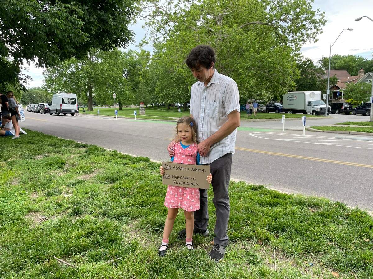 Cecilia Cox and her father Brad Cox at the March for Our Lives rally in Gillham Park Saturday afternoon. The eight-year-old said she felt proud to be there. Her father had been trying to explain the mass shooting in Uvalde, Texas since she heard about the incident over the radio. She held a sign that read: “Ban assault weapons. Ban high capacity magazines.”