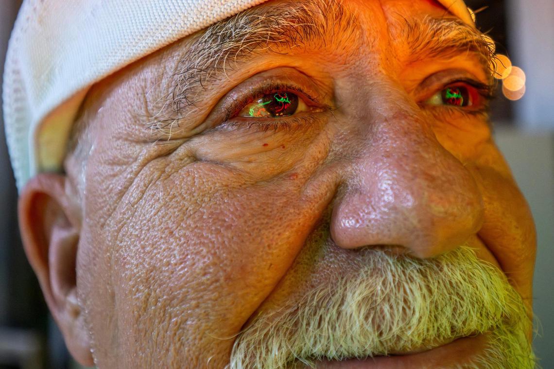 Nick Verdros, founder of the Lumi Neon Museum, smiles as the glow of a restored Kitty Clover Potato Chips neon sign reflects in his eyes. Vedros is confident that the restored 1935 sign and dozens of others will one day shine at at completed Pennway Point entertainment district.