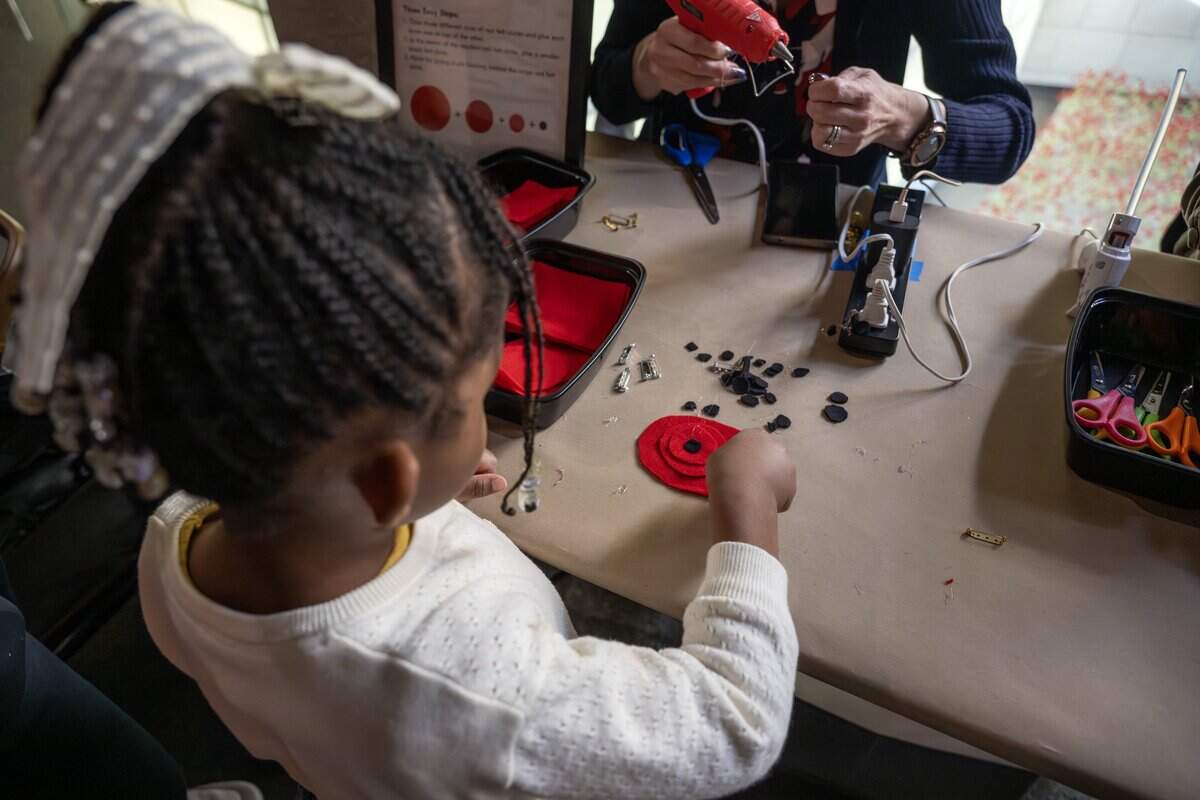 Four-year-old Emma Moss makes a felt poppy pin during a craft activity honoring Veterans Day at the National WWI Museum and Memorial on Tuesday, Nov. 11, 2025.