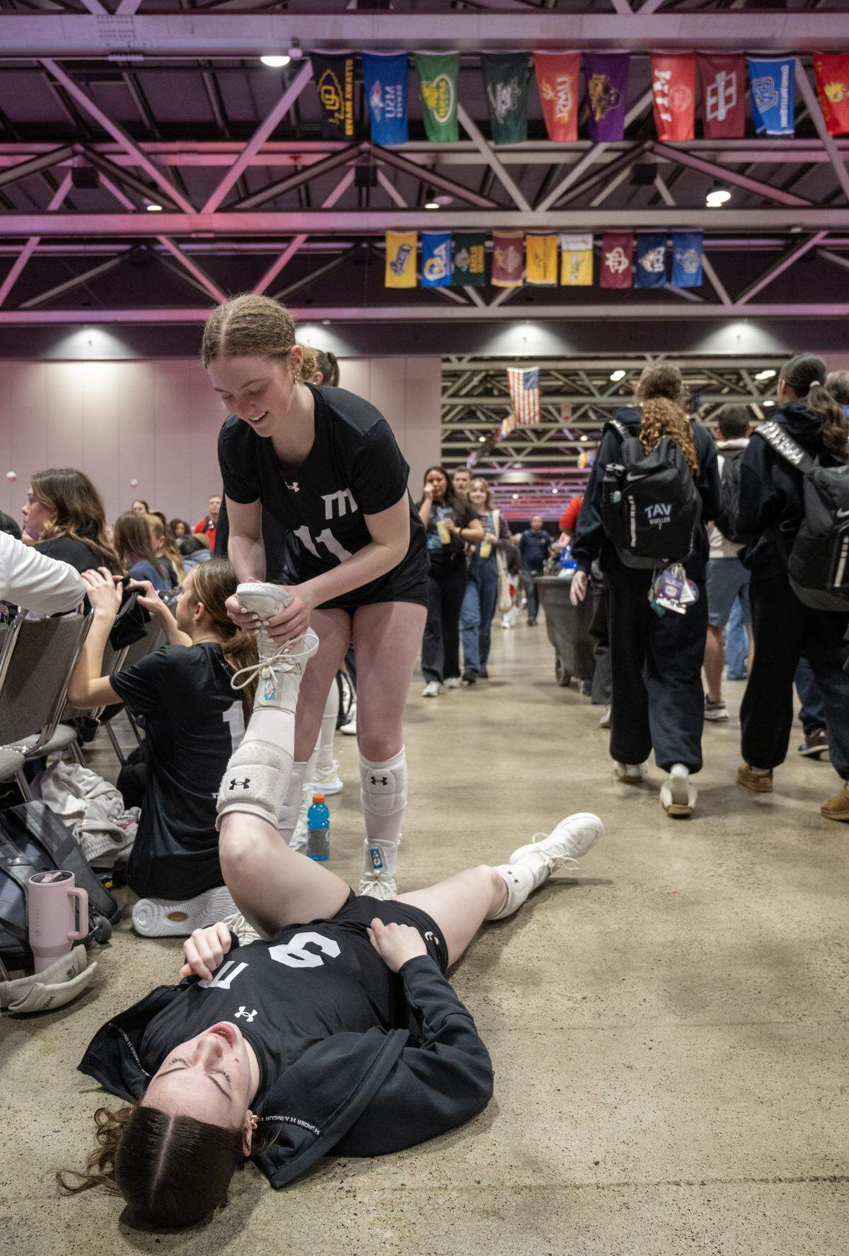 Members of the 1st Alliance Silver of Chicago, Kayla Street (9) has her foot worked on by teammate Brooklin Ritter (11) during some down time at The Triple Crown NIT Sunday, February 15, 2026 at Bartle Hall at the Kansas City Convention Center.