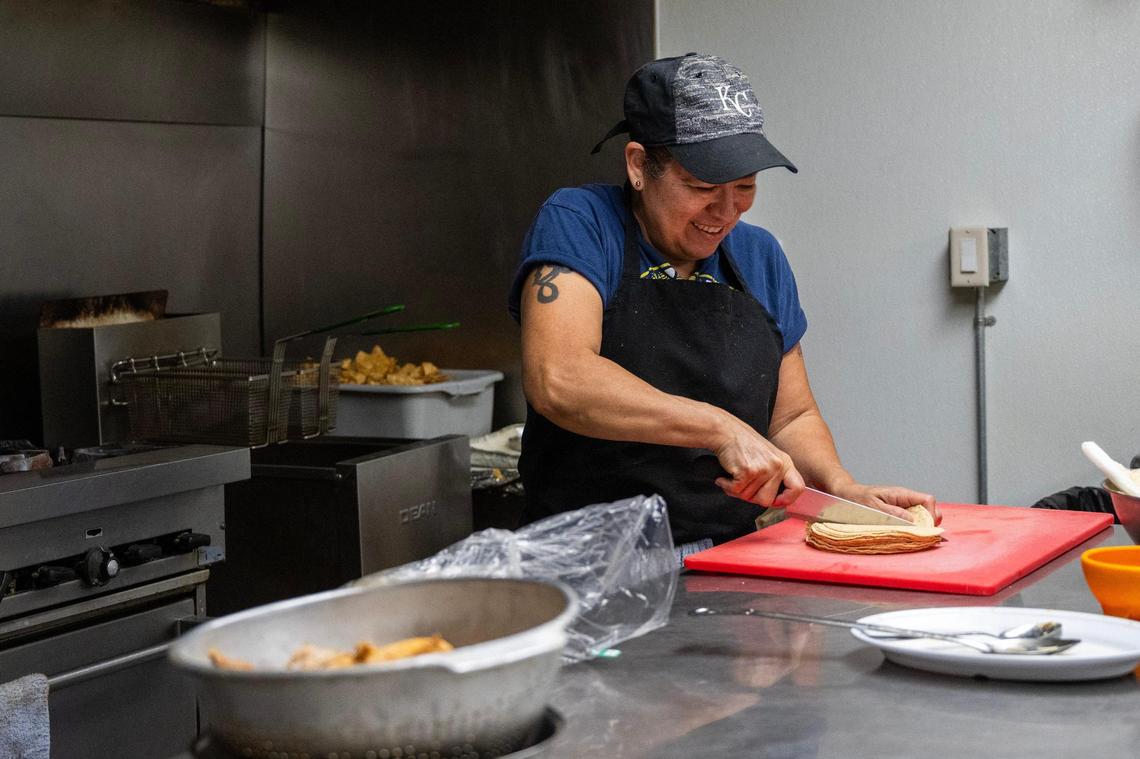 Martha Mendez, cook at La Fonda El Taquito, cuts tortillas in half.