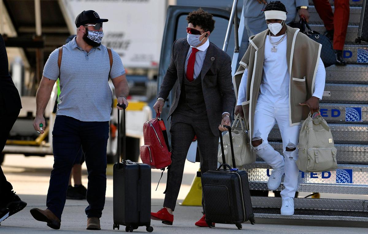 Kansas City Chiefs quarterback Patrick Mahomes, middle, chats with teammate Anthony Sherman after stepping off the plane Saturday evening upon arrival in Tampa, where they will take on the Tampa Bay Buccaneers in Super Bowl LV on Sunday.