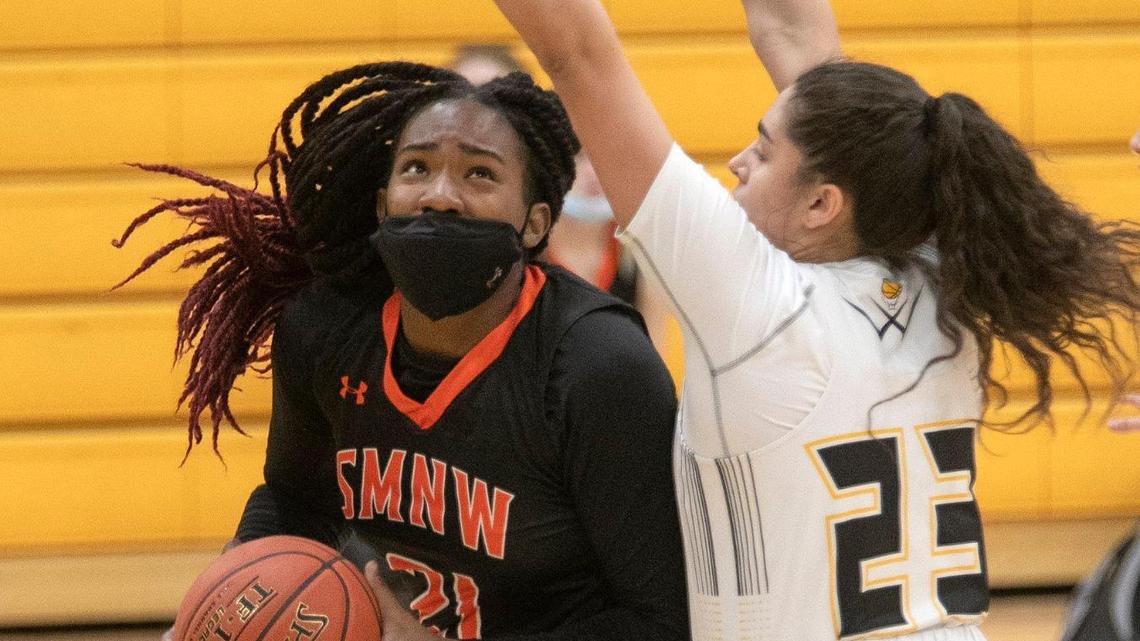 Kennedy Taylor, #21 (left) of Shawnee Mission Northwest went up against Taedyn Gray, # 23 of Shawnee Mission West, Friday, Feb. 12, 2012