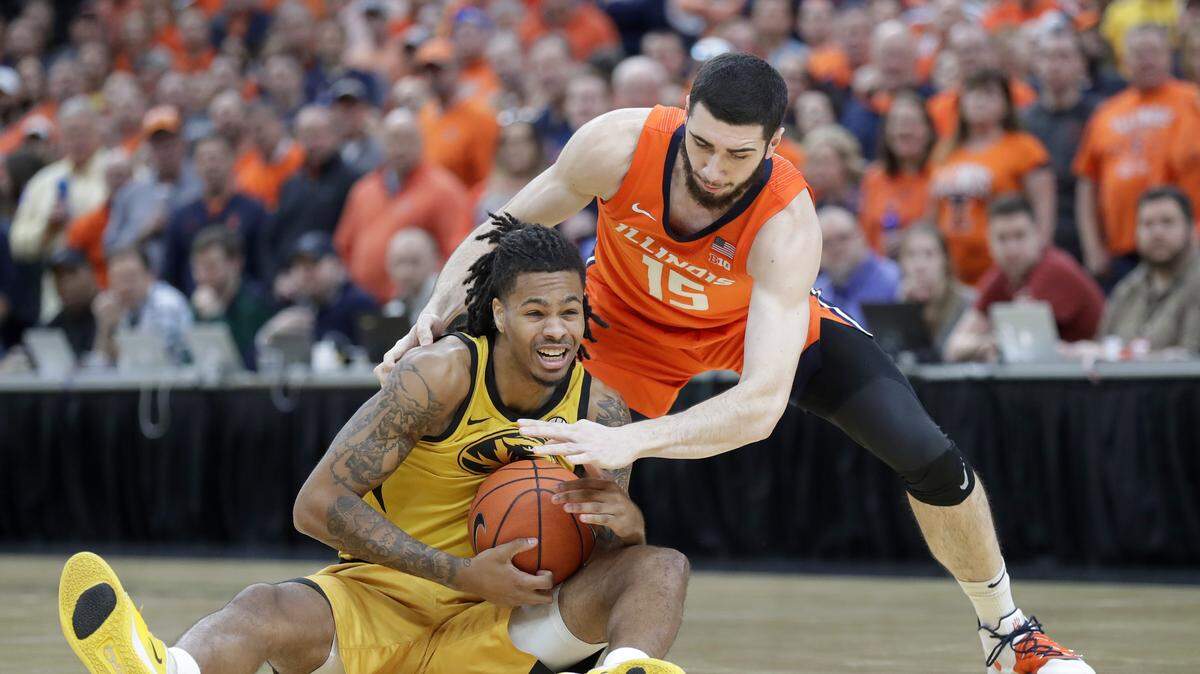 Missouri’s Mitchell Smith, left, and Illinois’ Giorgi Bezhanishvili (15) scramble for a loose ball during the first half of an NCAA college basketball game Saturday, Dec. 21, 2019, in St. Louis. (AP Photo/Jeff Roberson)