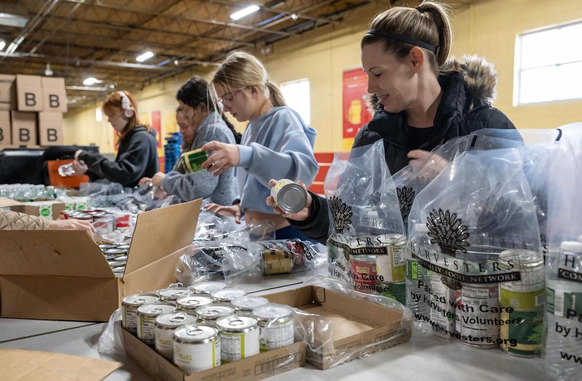 Volunteer Gretchen Schmanke of Overland Park, right, and others packed BackSnacks at Harvesters on the MLK Day of Service on Monday, Jan. 20, 2025, in Kansas City. The BackSnacks program provides food for elementary and some middles school students to take home over the weekend.