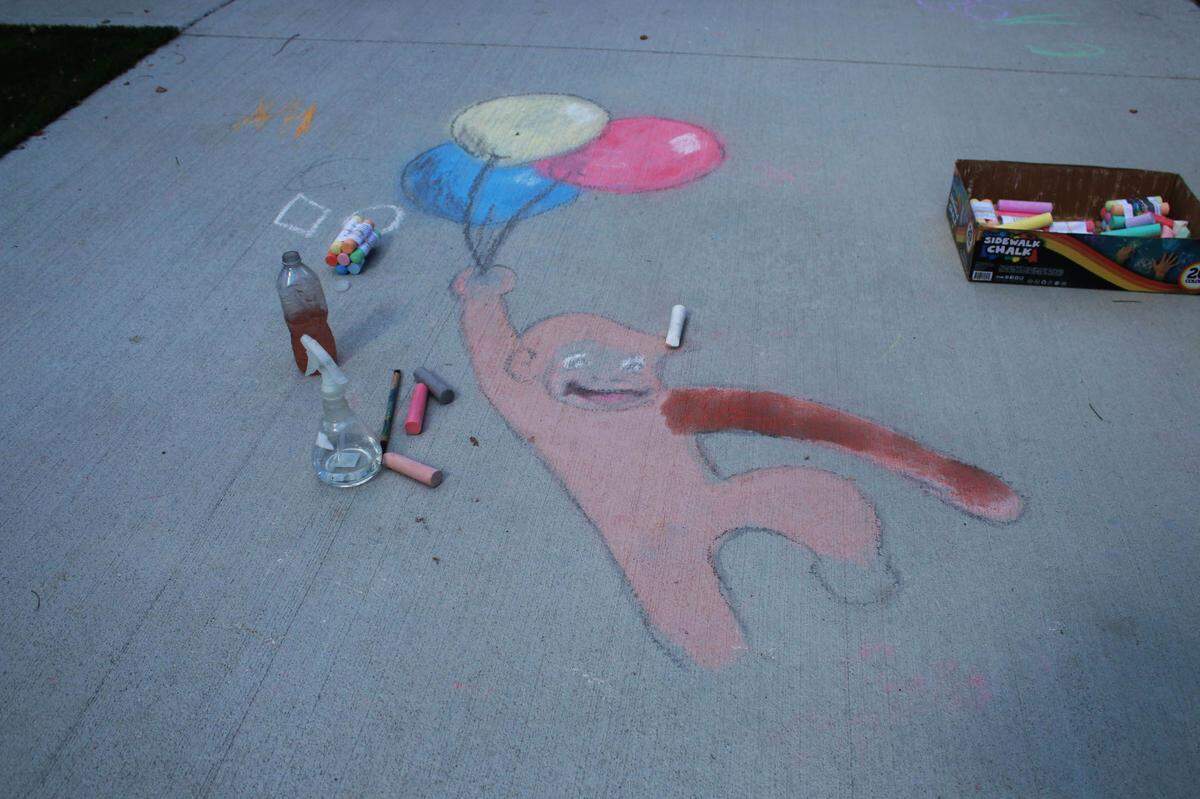An outline of a Curious George chalk artwork.