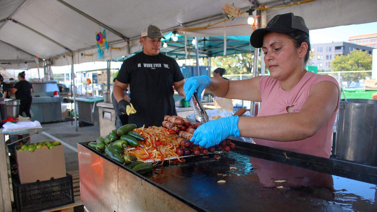 A food vendor prepares hot dogs and vegetables at Fiesta Hispana on Saturday, Sept. 13, 2025.