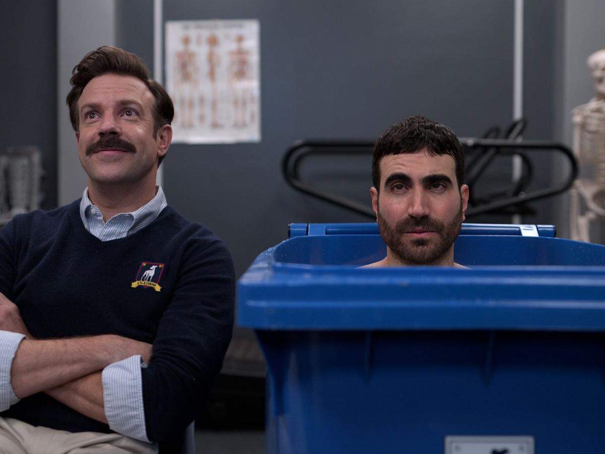 Jason Sudeikis, left, created and stars as Ted Lasso, an American football coach transplanted to a British soccer club. Roy Kent, the mercurial team captain, is played by Brett Goldstein, one of the show’s writers.