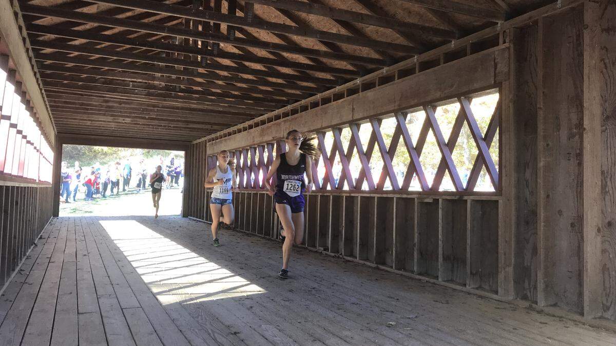 Blue Valley Northwest’s Riley Beach crosses Rim Rock Farm’s King’s Bridge during the Kansas cross country championships on Saturday in Lawrence.