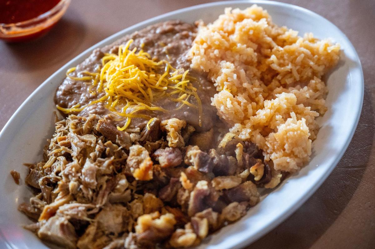 A plate of carnitas, refried beans topped with cheese and red rice is served at La Fonda El Taquito on Saturday, Sept. 28, 2024, in Kansas City.