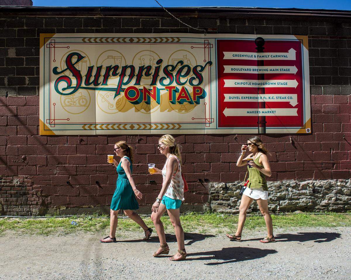 Festival-goers pass by a sign on Saturday, June 20, 2015, during Boulevardia in the West Bottoms.