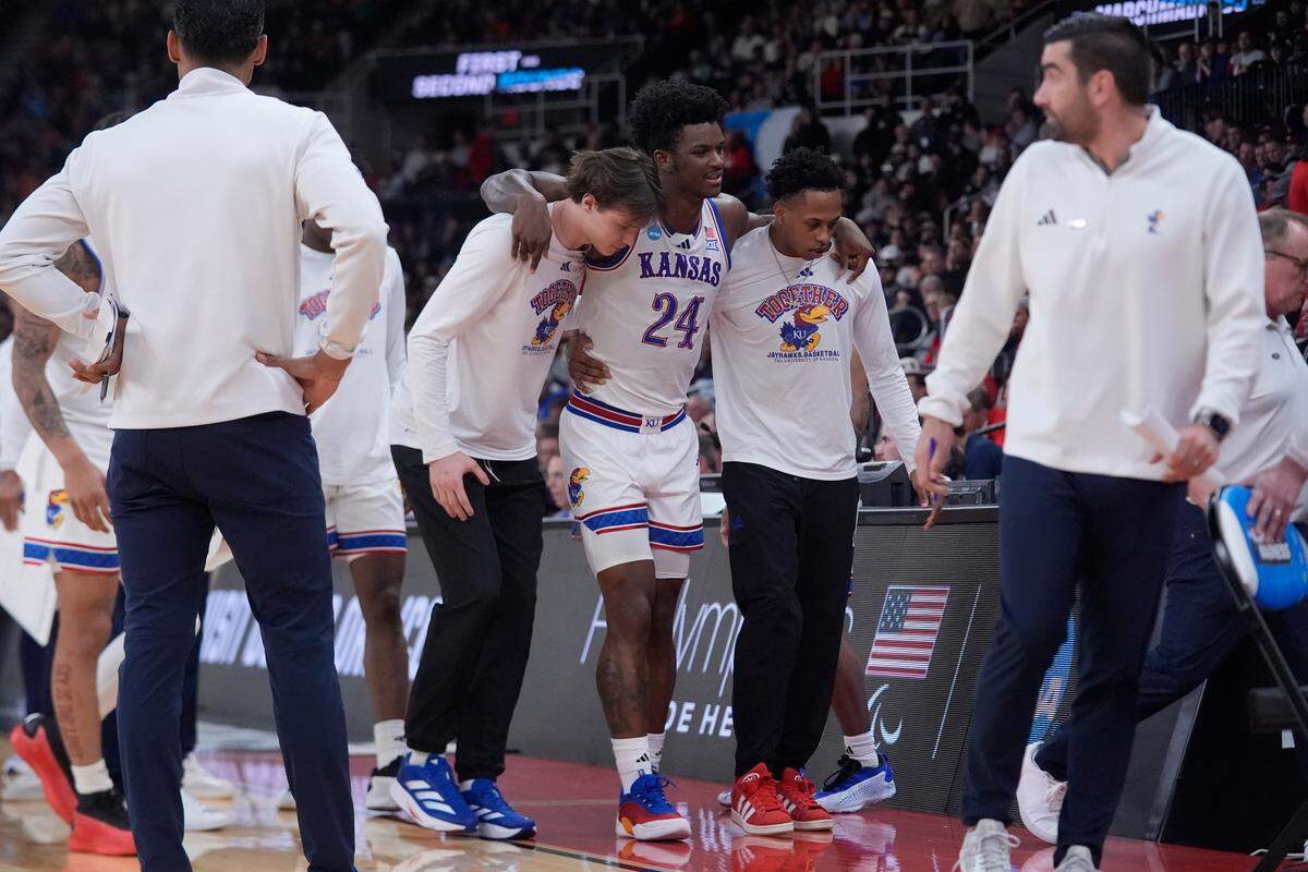Kansas Jayhawks forward KJ Adams Jr. (No. 24) is helped off the court and on to the locker room after suffering an injury late in an NCAA Tournament game against the Arkansas Razorbacks at Amica Mutual Pavilion in Providence, Rhode Island, on Thursday, March 20, 2025.