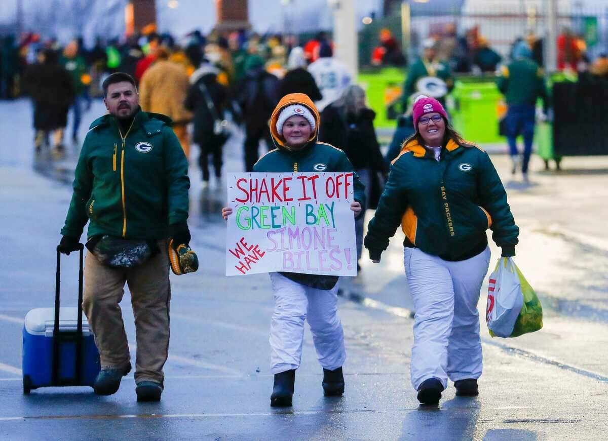 A young Green Bay Packers fan carries a sign claiming that gymnast Simone Biles is the better celebrity fan before a game against the Kansas City Chiefs on Sunday, December 3, 2023, at Lambeau Field in Green Bay, Wisconsin.