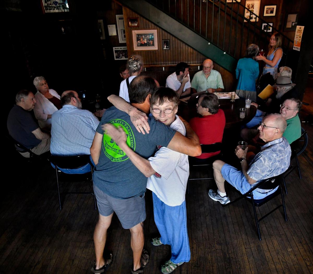 Kyle Kelly, left, gets a hug from longtime patron Suzanne Smith. “We used to be in here every Monday and Thursday, but it’s scaled back. We talk sports, football, recipes, politics, whatever,” she said.