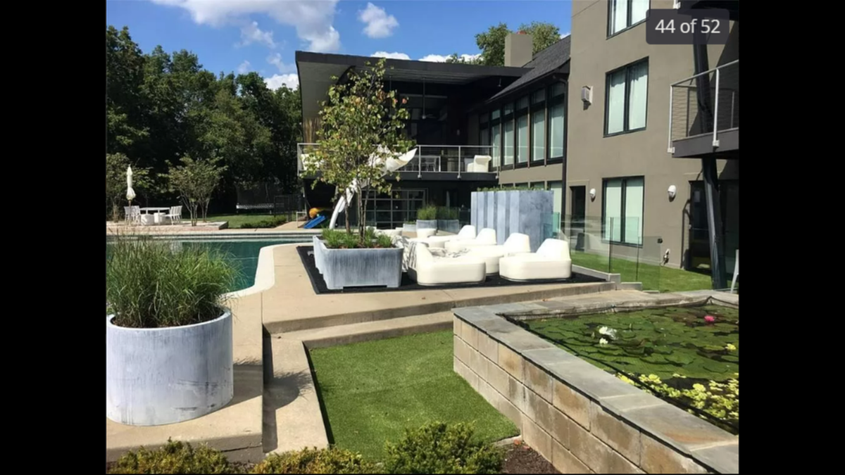The backyard at the home at 14420 Mission Road in Leawood features a heated pool, an outdoor terrace with a fire pit and a koi pond with a waterfall.