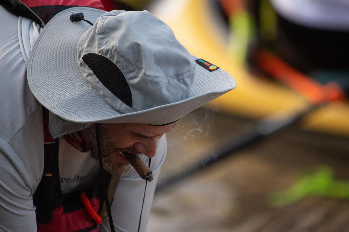 An MR340 competitor smokes a cigar as he and his teammate ready their boat at Kaw Point.