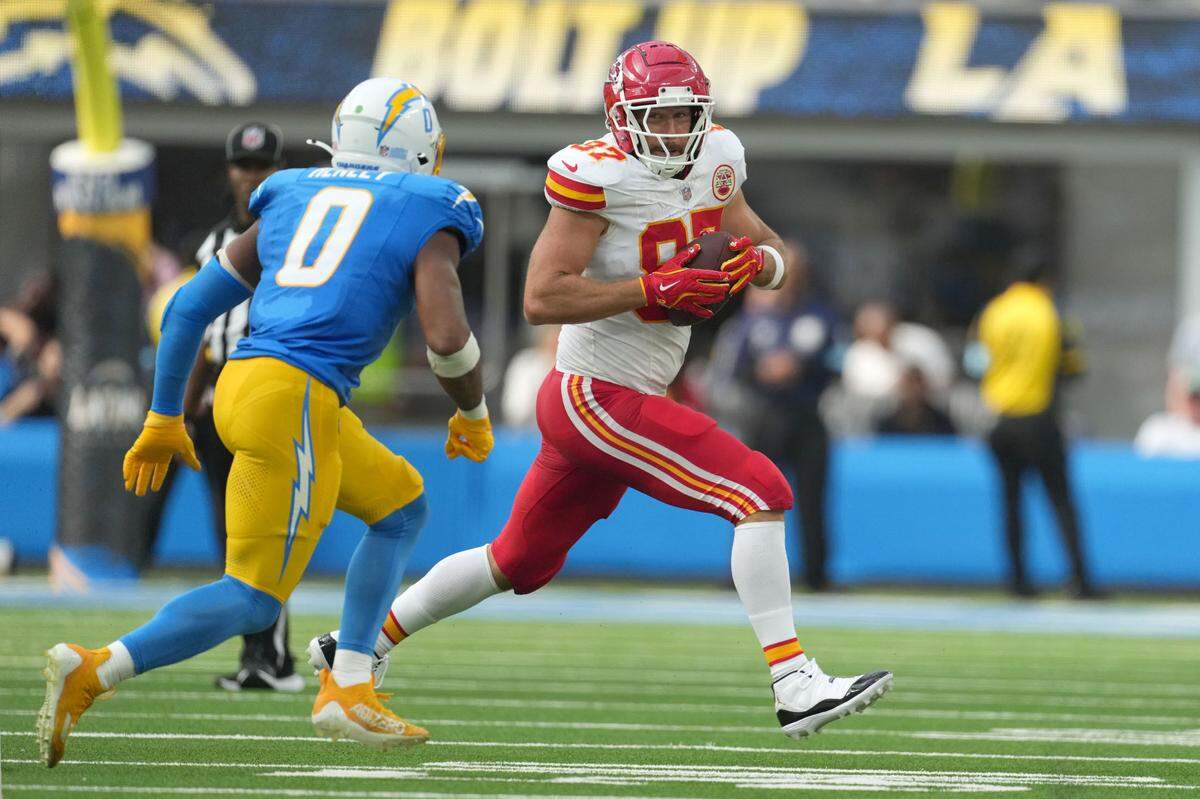 Kansas City Chiefs tight end Travis Kelce (87) runs against Los Angeles Chargers linebacker Daiyan Henley (0) in the second half at SoFi Stadium.